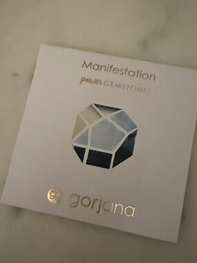 Gorjana White Card with Metallic Gold Logo and Blue Gem Graphic